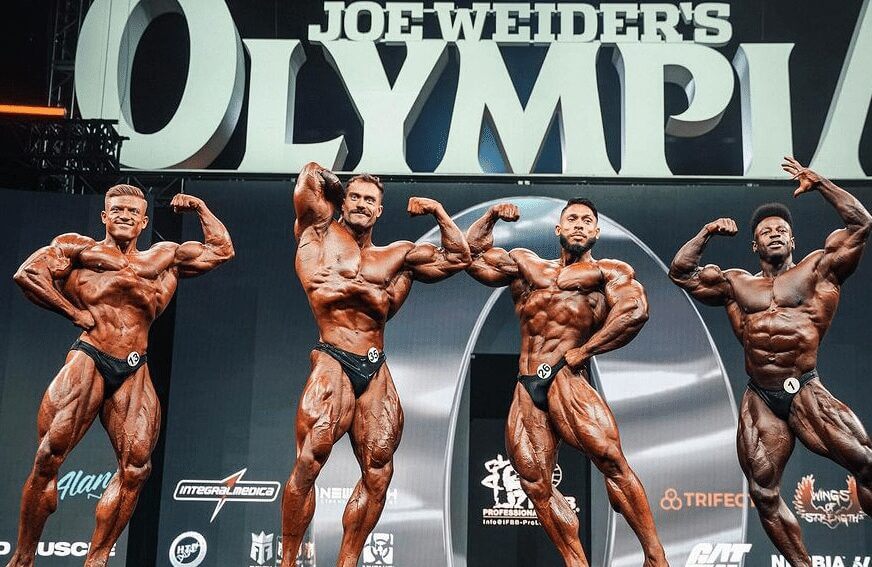 Urs Kalecinski, Chris Bumstead, Ramon Dino und Breon Ansley zusammen auf der Bühne bei ihrer Teilnahme am vergangenen Mr Olympia.