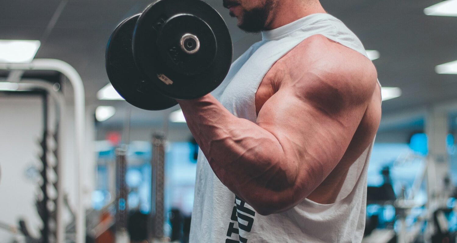 Ein starker Bodybuilder absolviert Bizepscurls.