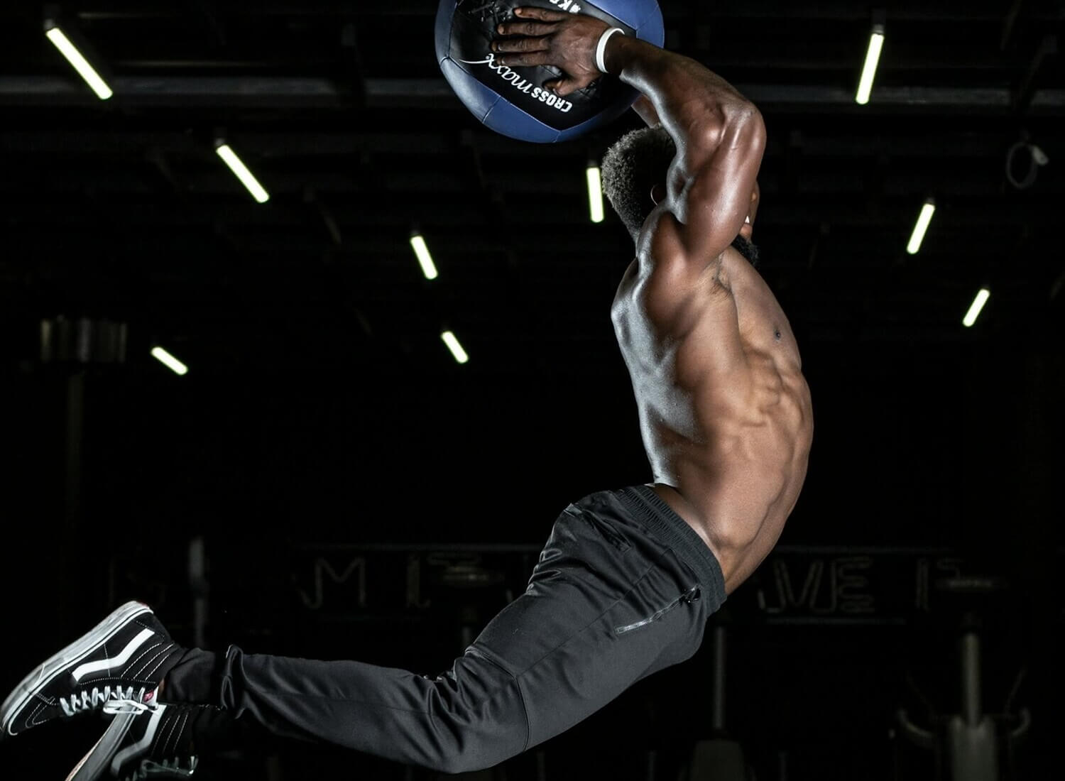 Ein Crossfit-Kraftsportler springt mit einem Medizinball.